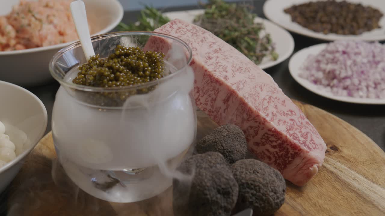 느린 패닝  ⁇ 은 모차 ⁇ 라, 토마토, 양파, 카퍼, 아루쿨라와 같은 다양한 재료를 드러 ⁇ 니다. 모두 마른 얼음 위의 카비아르를 중심으로 하여 매혹적인 효과를 창출합니다.