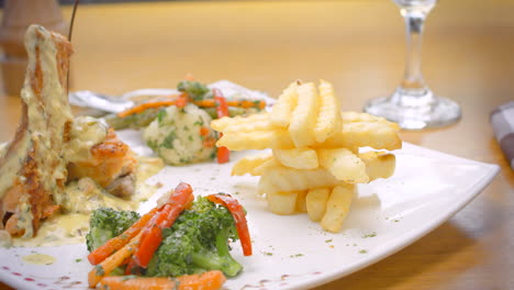 salmon in white sauce, french fries and steamed vegetables, mediterranean