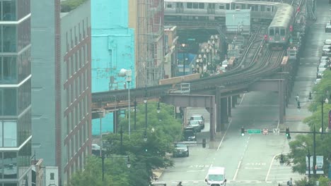 tren elevado en el centro de chicago en cámara lenta con flujo de tráfico y peatones