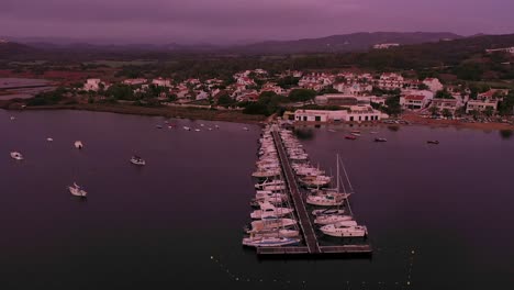 Vista-Aérea-De-Barcos-En-Un-Muelle-Durante-Un-Amanecer-En-Menorca-España-Seguimiento-Plano-General