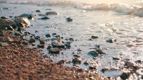 movimiento lento de arena de guijarros en la playa con la llamarada del sol.
