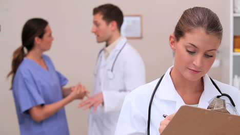 smiling doctor writing on her clipboard