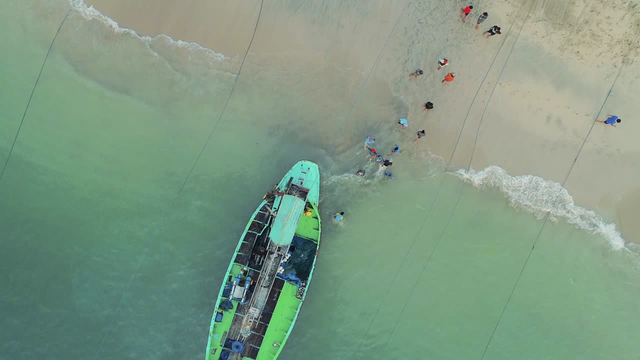 지역 어부들이 해가 뜨면 배에서 잡은 물고기를 해변으로 내리는 모습 (공중에서 볼 수 있는 사진, 인도네시아)