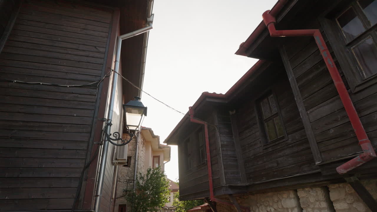 Traditional wooden houses with vintage street lamp in narrow old Nessebar street Bulgaria