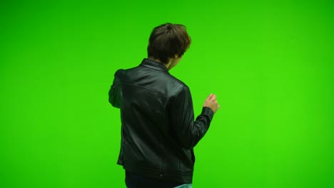 man dancing on green screen at studio. back view. chroma key