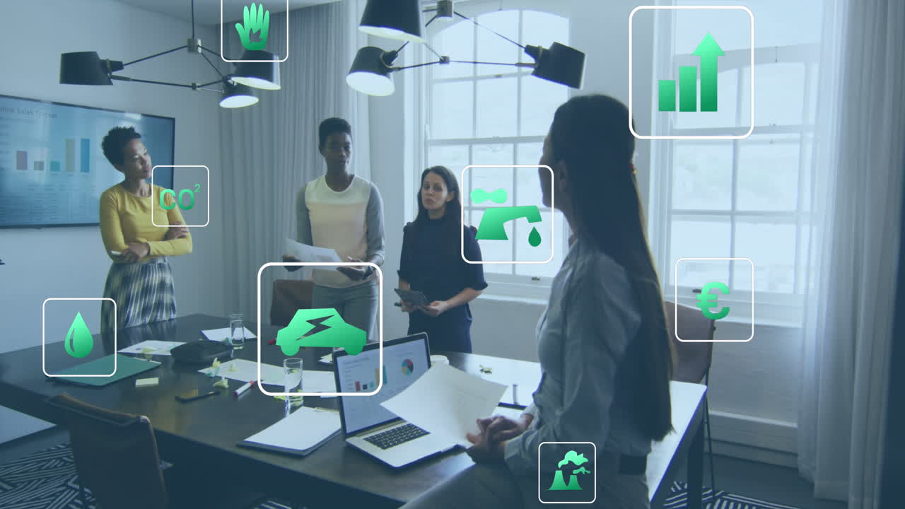 Animation of icon in squares over diverse female coworkers discussing reports in office