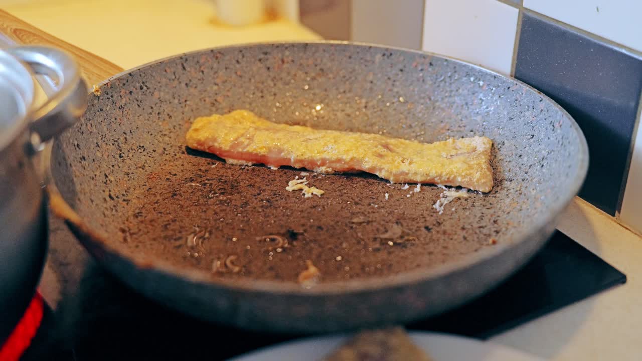 Frisk torskefilet placeret på pande under madlavning derhjemme for en sund livsstil