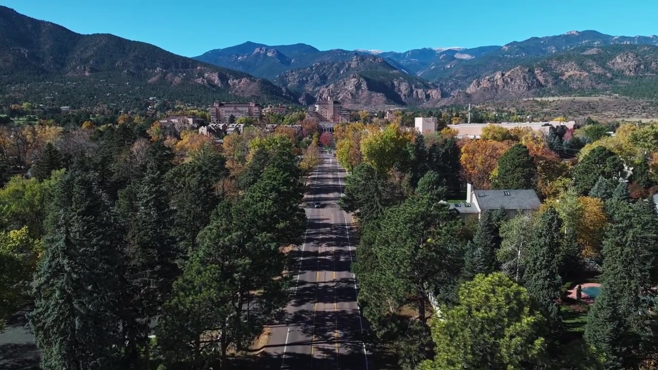 Carrellata aerea segue la strada che porta al resort The Broadmoor a Colorado Springs, circondato da alberi autunnali colorati