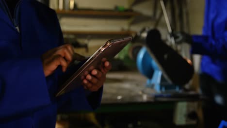 sección media de un trabajador que usa una tableta digital en una fábrica de vidrio 4k
