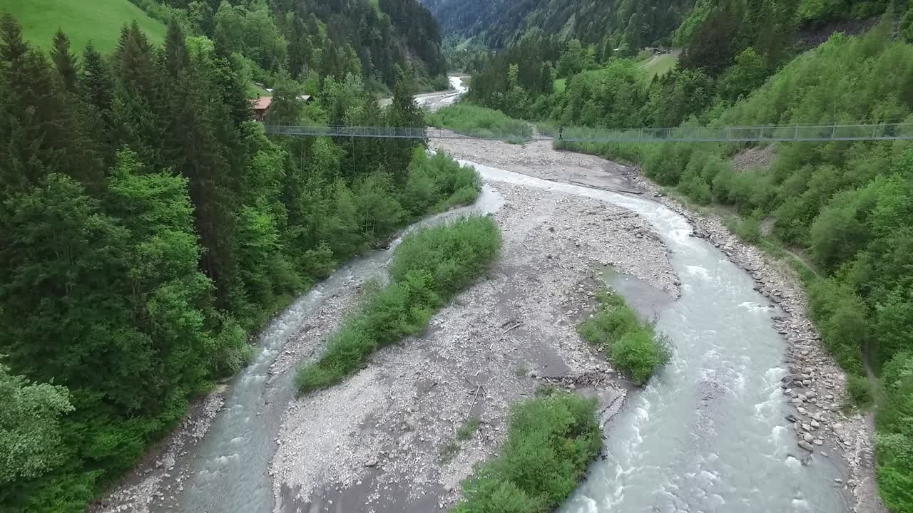 valle de un río de montaña con puente colgante