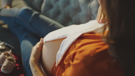 pregnant woman looking at baby clothes