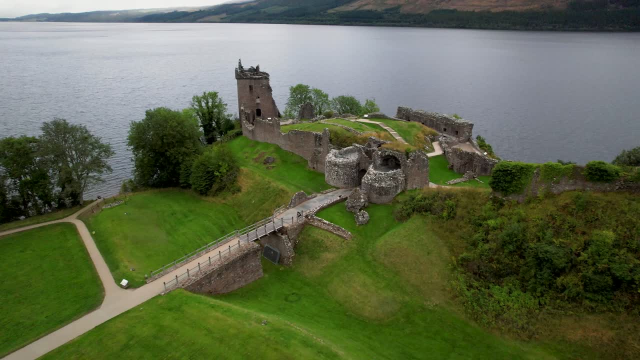 руины шотландского замка на берегу озера лох-несс - шотландские высокогорные земли - воздушный полет в