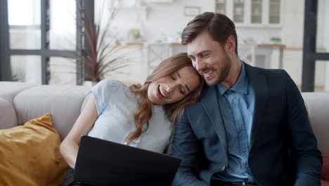 pareja feliz usando una computadora portátil en casa