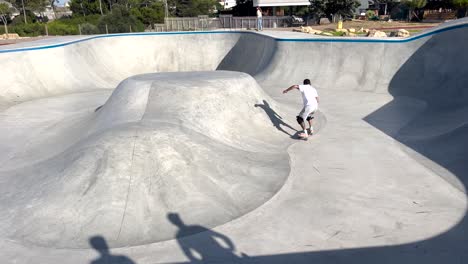 close-view-of-man-ascends-a-ramp-near-the-sea-in-Cascais-with-a-surfskate,-training-for-riding-the-lip-while-surfing