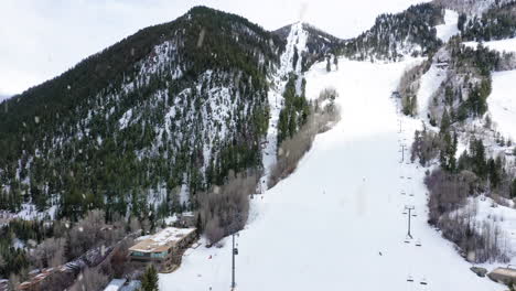 Skipiste-Und-Lift-Im-Winterresort-Bei-Schneefall,-Seitliche-Luftaufnahme