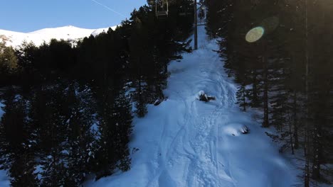 Ein-Schuss-Von-Oben-Eines-Immergrünen-Waldes-Auf-Einem-Schneebedeckten-Berg-Während-Der-Fahrt-Auf-Einem-Skilift