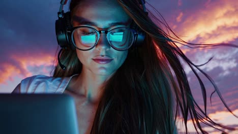 ingeniero de software hábil trabajando con concentración en la computadora portátil, capturando momentos de tecnología innovadora durante el ambiente de puesta de sol azotado por el viento, el cabello fluyendo con energía profesional digital