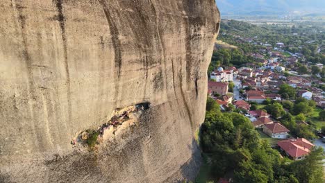 approaching a wide decorated cave in meteora, greece with a drone, aerial