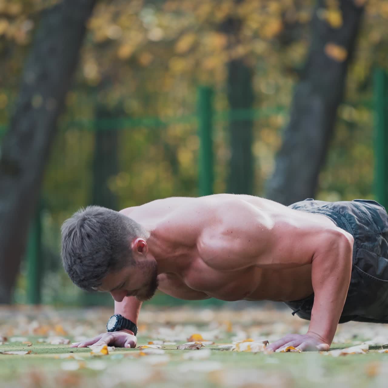 . Young sportsman doing push ups. Handsome sport man doing push ups in the park