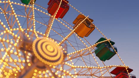 Colorida-Noria-Girando-Lentamente-En-El-Parque-De-Diversiones-Con-El-Cielo-Al-Fondo.-Montar-En-Carrusel-Representa-Entretenimiento-Y-Diversión.-Bucle-Sin-Fin-Y-Sin-Interrupciones.-Cielo-Azul-En-El-Fondo.