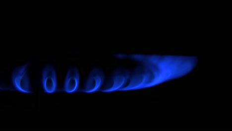 gas burning from a kitchen gas stove, dark background, cold winter and energy crisis concept, closeup shot