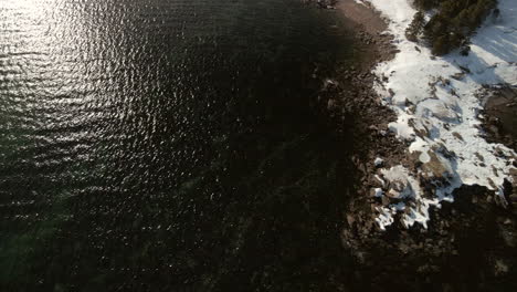 Drone-flight-over-the-ocean-in-winter-with-snow-in-Chandler,-Quebec,-Canada