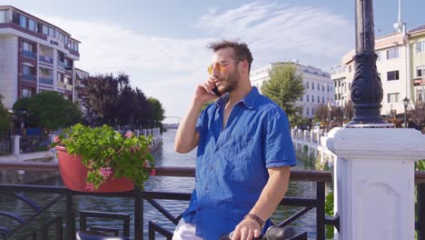 young man talking by phone in modern city.