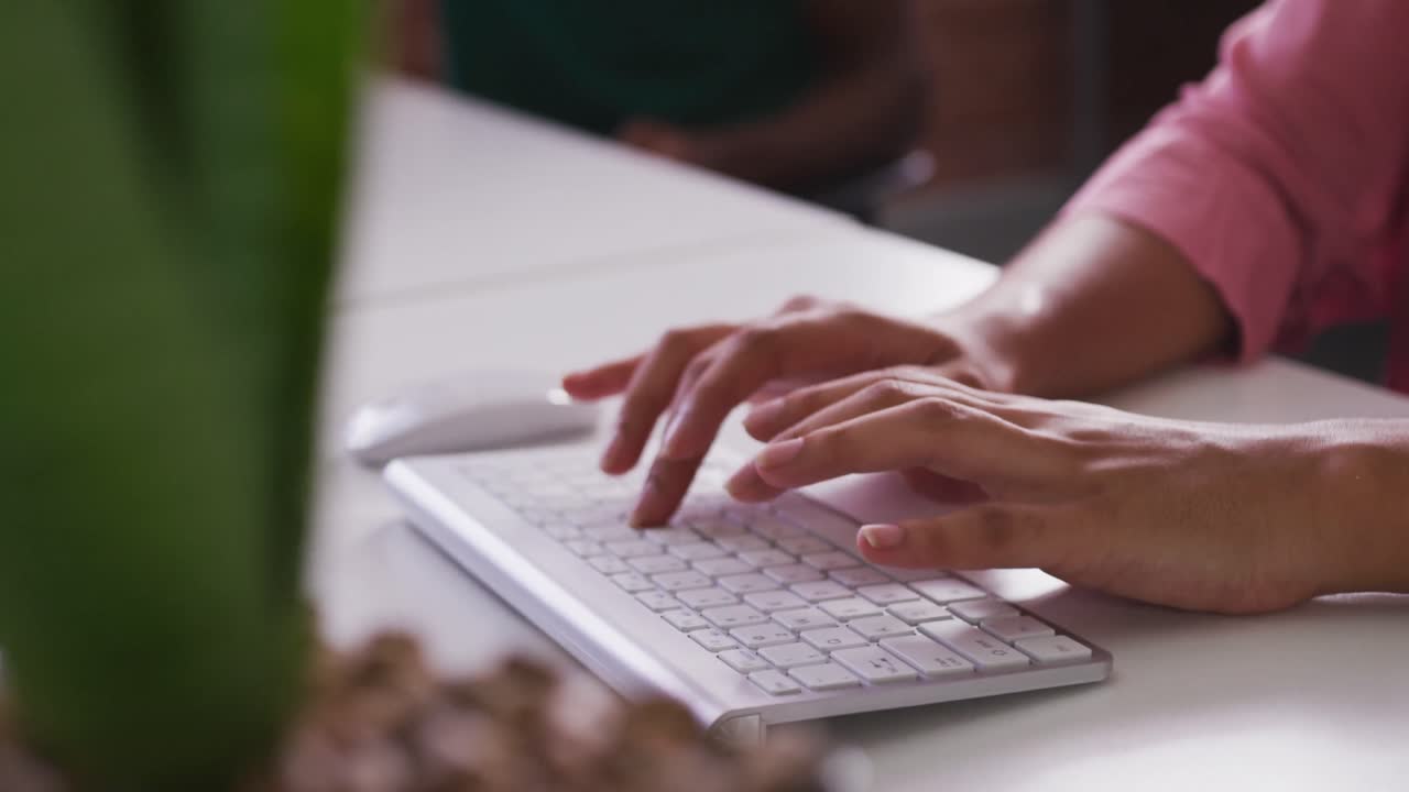 Close up of mixed race businesswoman's hands typing on computer keyboard
