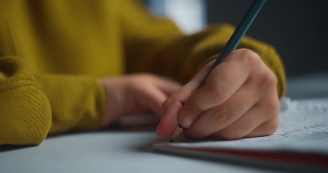 Focused Child Drawing with Pencil and Wearing Headphones