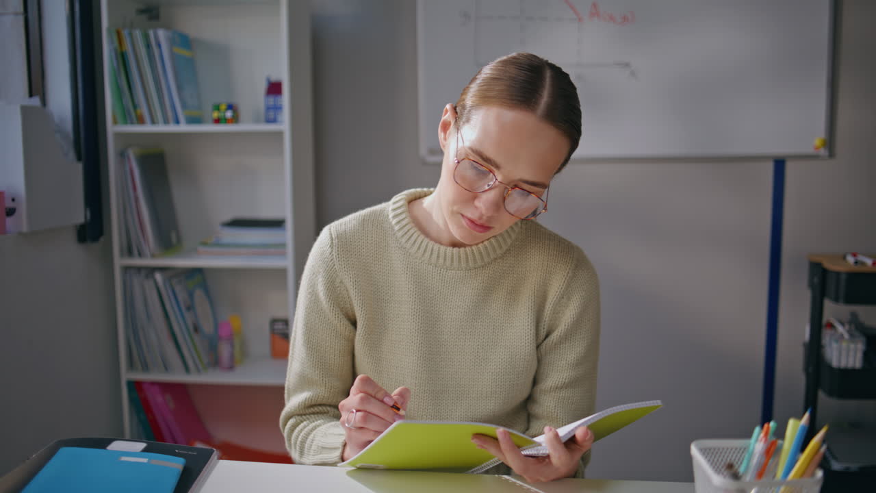School woman preparing exam at light apartment closeup. Girl in glasses reading