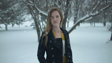 mujer feliz afuera en cámara lenta nieve de invierno como copos de nieve caen en cámara lenta cinematográfica