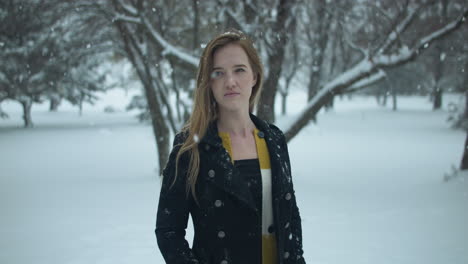 happy woman outside in slow motion winter snow as snowflakes fall in cinematic slow motion