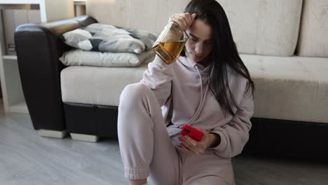 woman with bottle of alcohol on head looking at phone, representing addiction or distress