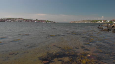 Drohne-Fliegt-Dicht-über-Wasser.-Hafen-Im-Hintergrund