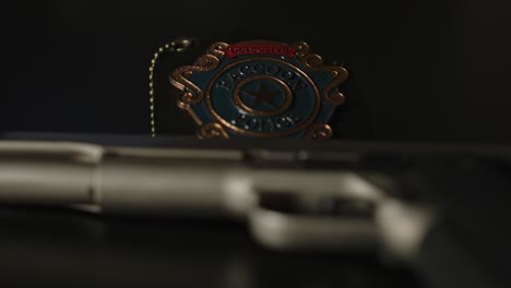 close up of a police badge with a out of focus gun in the foreground