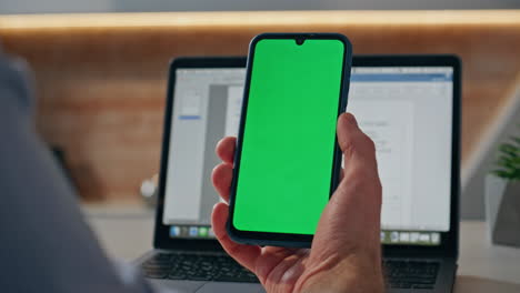man hands holding mockup mobile phone in office closeup. creator reading device