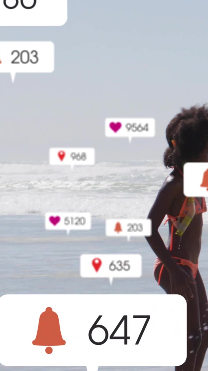 Vertical video: Girl walking right while social bell and heart badges appearing overlapping her