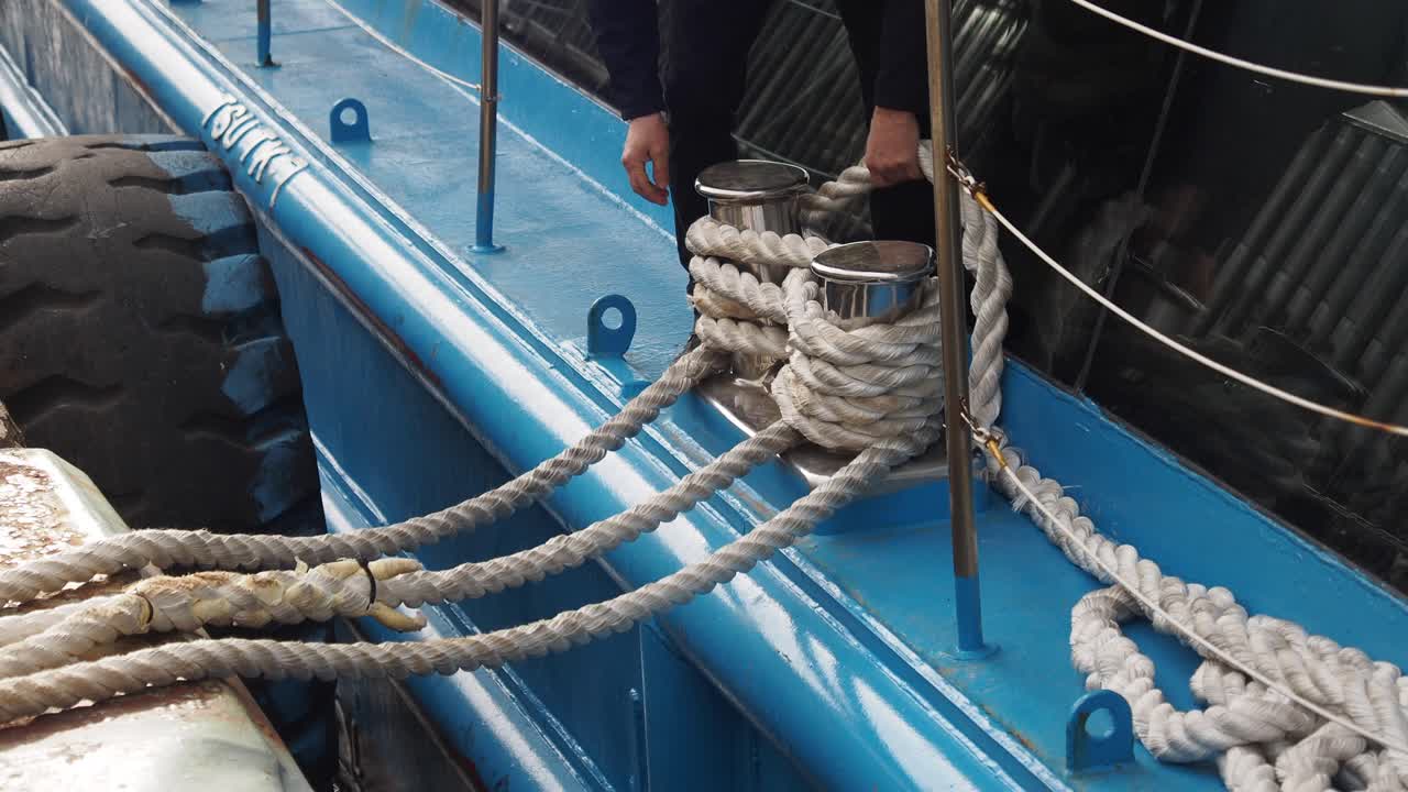 hombre atando un barco en un muelle