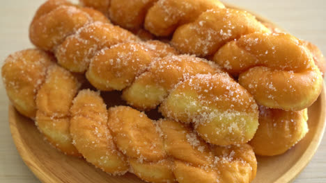 sugar-doughnut-in-spiral-shape-on-wooden-plate