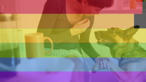 animación de orgullo rayas de arco iris sobre feliz mujer caucásica y perro mascota en la cocina