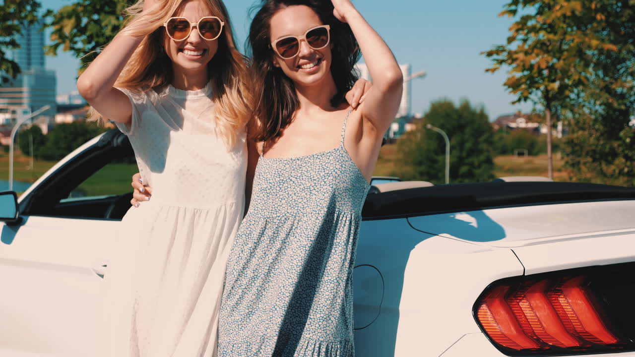 두 여인이 컨버터블에서 도시를 즐기고 있습니다.