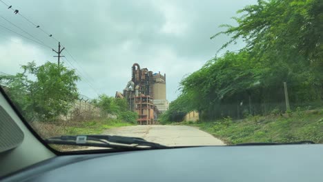 a point-of-view (pov) shot of a car approaching a factory