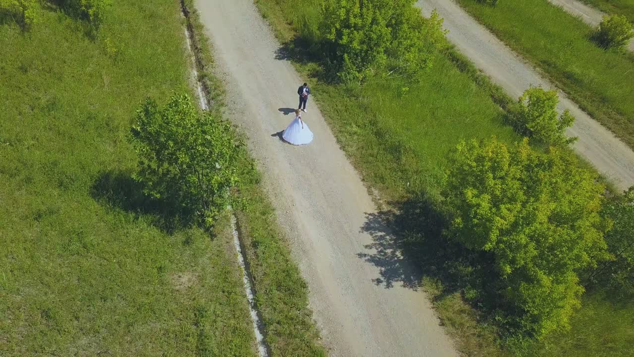 행복 한 신부 는 공원 도로 위쪽 에서 신부 를 보고 회전 한다