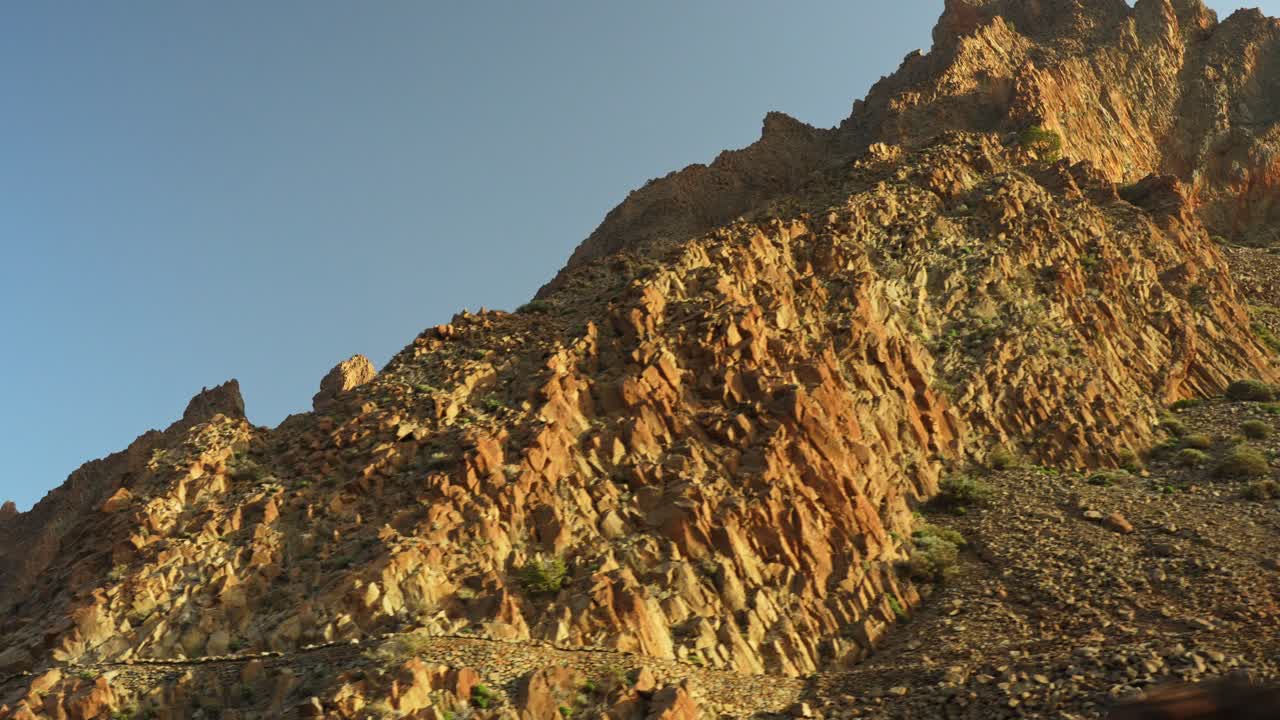 conduciendo cerca de las montañas rocosas en el parque nacional del teide en tenerife durante la puesta de sol, pov closeup bajo ángulo