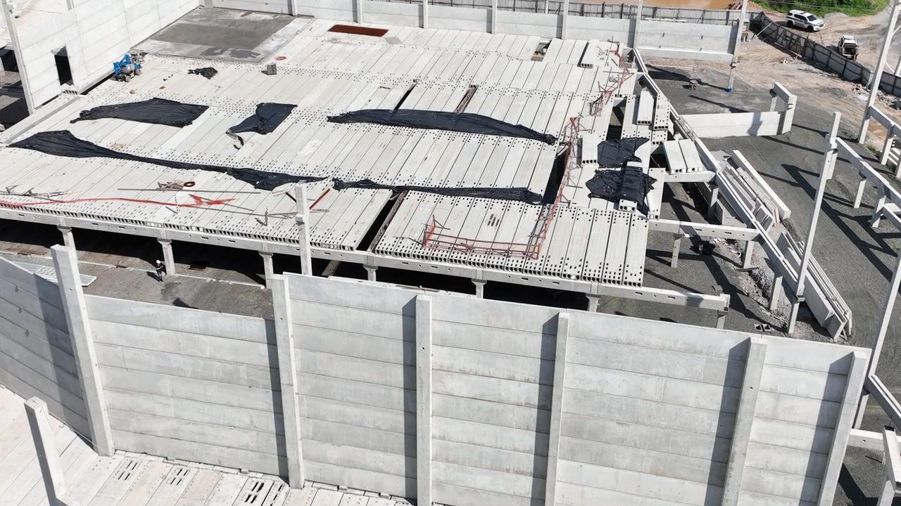Edificio moderno prefabricado de hormigón en construcción con columnas prefabricadas, paneles de muro y losas de piso alveolares, vista aérea