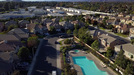 drone reveal shot over residential neighborhood with pool in the suburbs