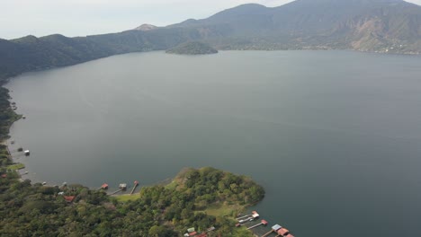 drone footage of coatepeque caldera lake in el salvador with surrounding hills and mountains