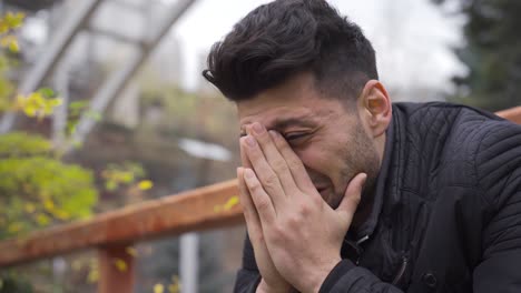 sadness, loneliness. the young man is crying outdoors and his nerves are broken.