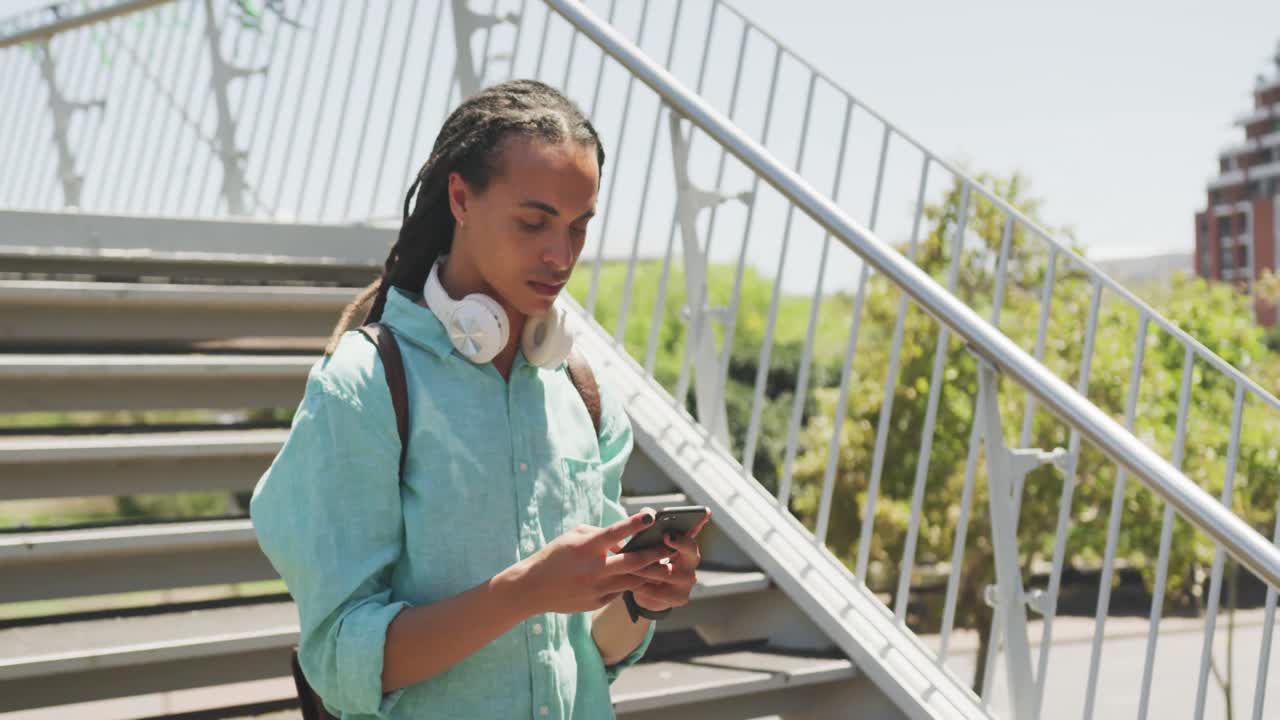 Mixed race man using his phone outside