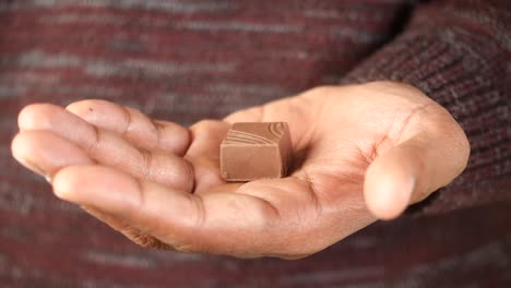 mano con una golosina de chocolate